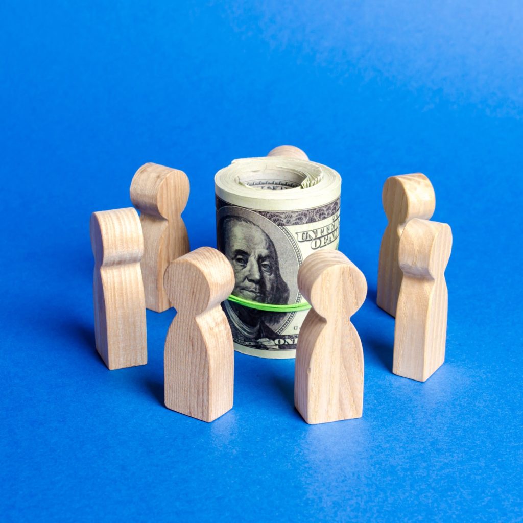 Figures of people surround a bundle of money